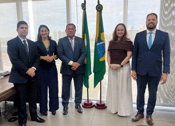 A imagem é um registro fotográfico. Nele, quatro pessoas estão posando para a foto. Entre eles, ...