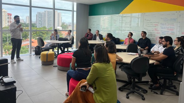 Registro fotográfico feito durante o I Diálogos de Inovação. Em uma sala com cores vibrantes e j...