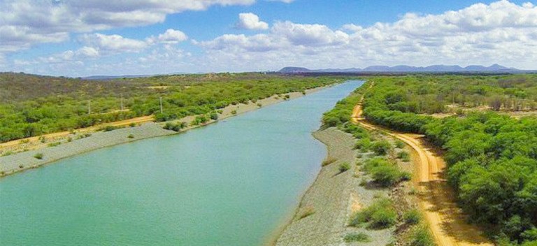 Registro fotográfico feito em plano vertical. Nele, há um trecho do Rio São Francisco, com árvor...